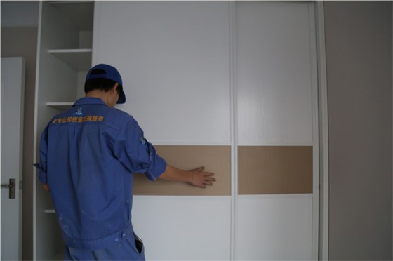 家具安裝工正在現(xiàn)場進(jìn)行實木衣柜維修工作