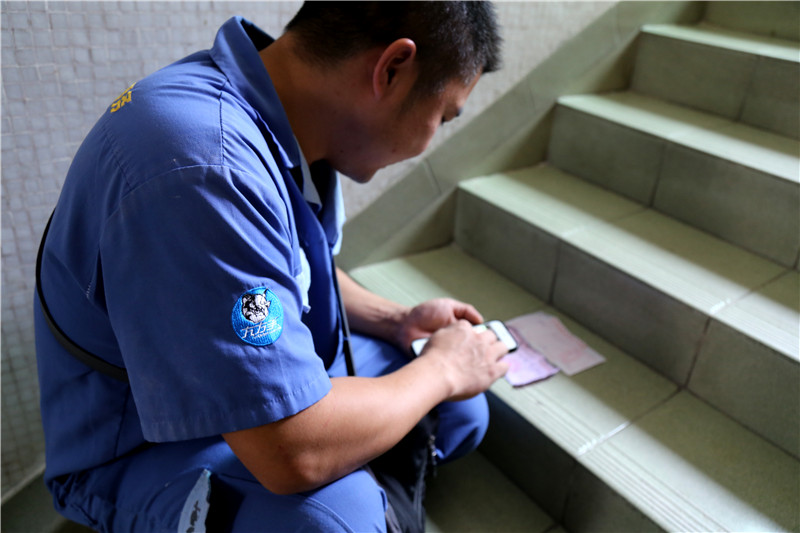 客戶還是沒有到，家具安裝謝師傅蹲在門口等，一邊等一邊處理今天要去的下一家客戶的資料