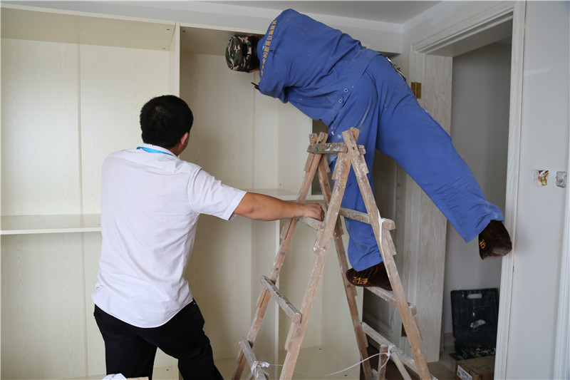 左右手家具安裝師傅彼此合作，完成家具安裝工作