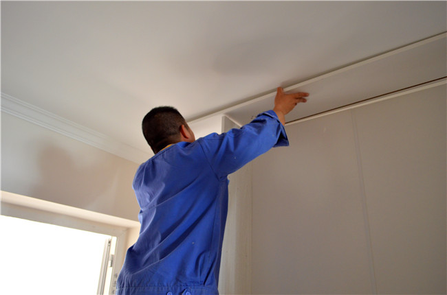 家具修補(bǔ)工正在處理衣柜頂線(xiàn)問(wèn)題